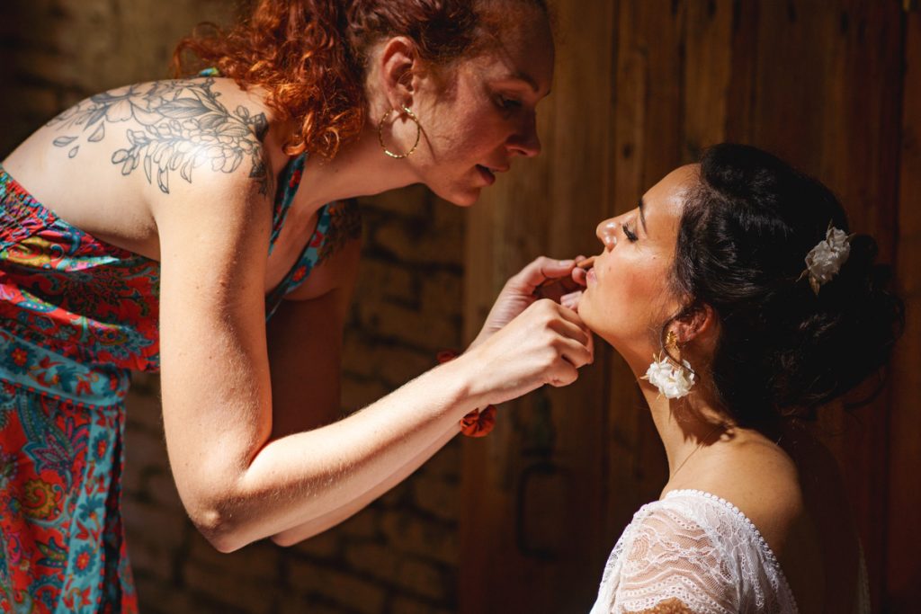 une mariée qui se fait maquiller lors des préparatifs de son mariage