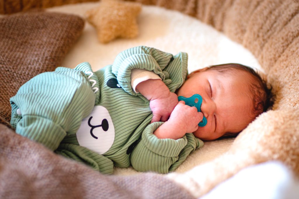 Bébé qui dort dans son couffin en séance photo nouveau-né