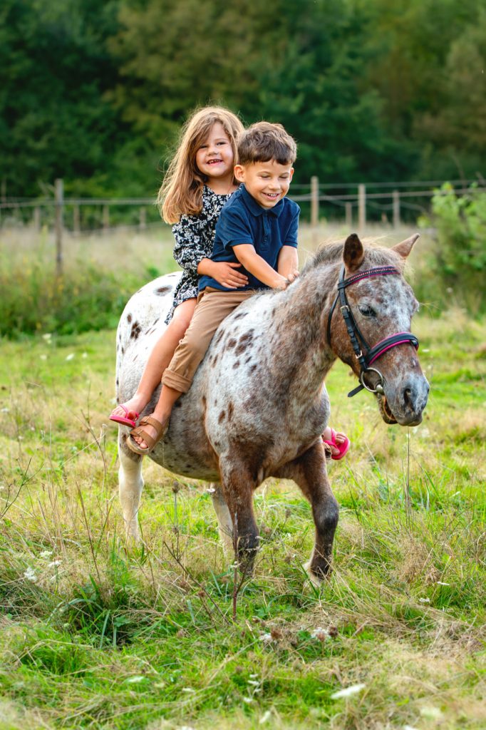 Des frères et soeurs sur leur poney pour une séance photo en famille à Saint-Lys