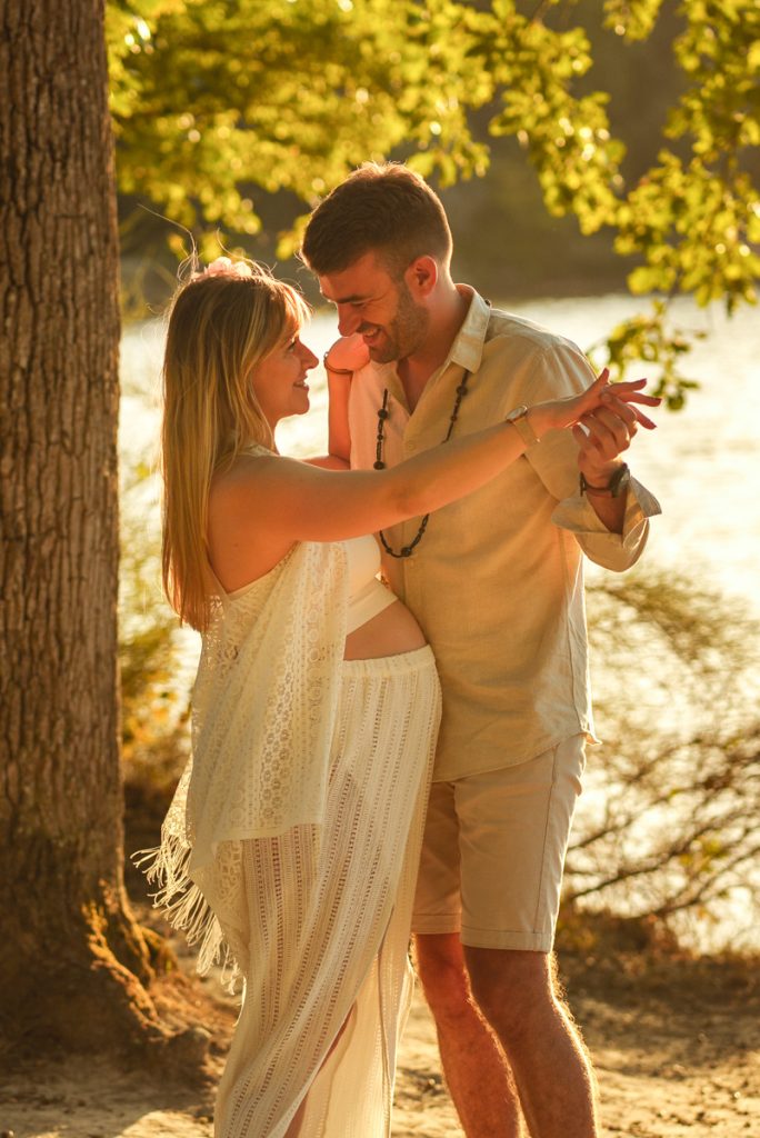 Couple qui danse au coucher du soleil pour une séance photo grossesse