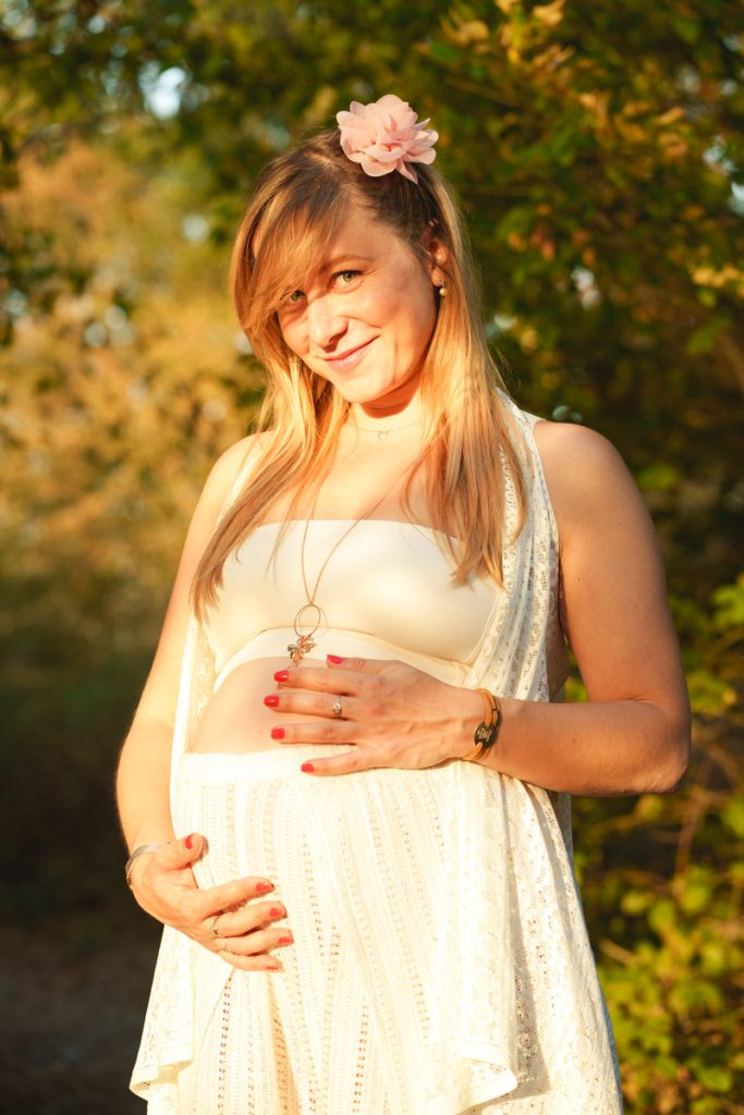 Un jeune femme enceinte avec une fleur dans les cheveux lors d'une séance photo grossesse à Toulouse