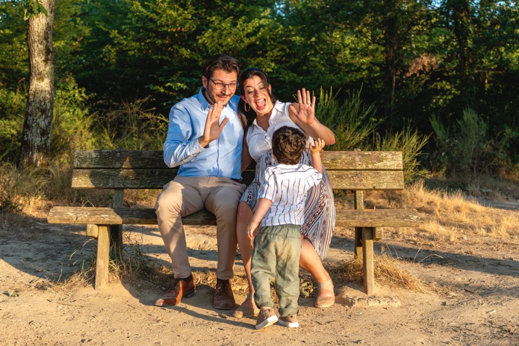 Un couple avec une femme enceinte et un enfant qui se tape dans la main sur un banc à Tournefeuille