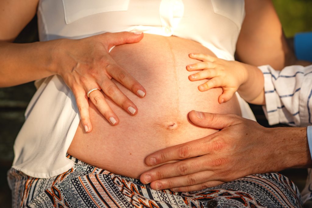les mains de toute la famille qui touche le ventre de la maman à Blagnac