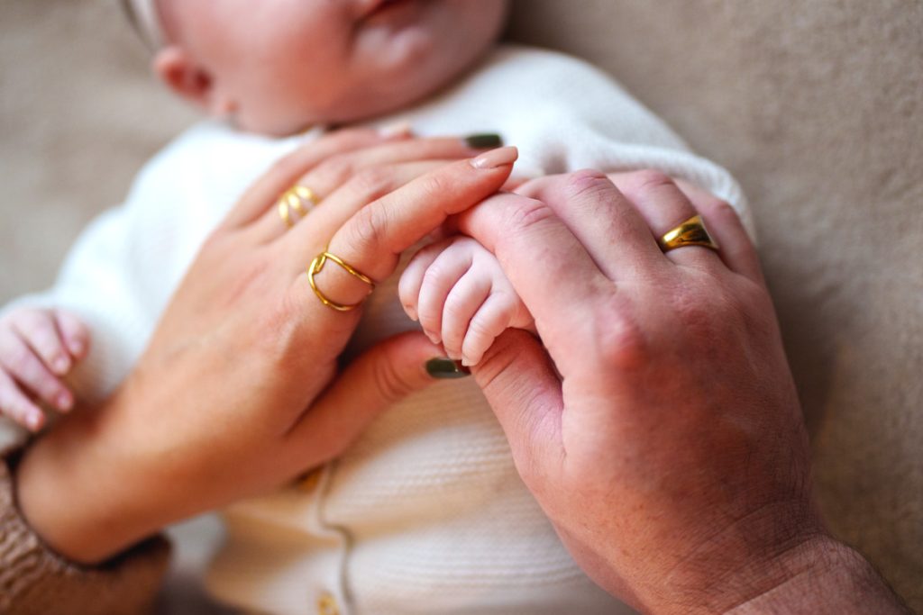 Grossesse et Naissance : La main d'un nouveau-né tenue par ses deux parents