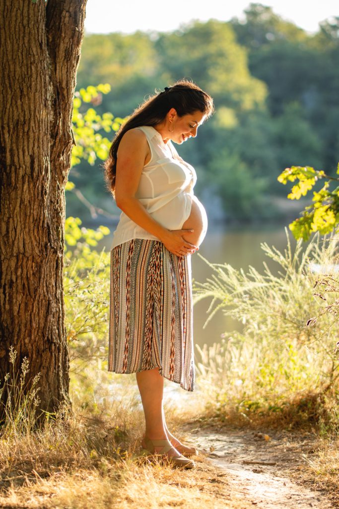 Une femme enceinte au bord d'un lac en séance photo grossesse à Tournefeuille