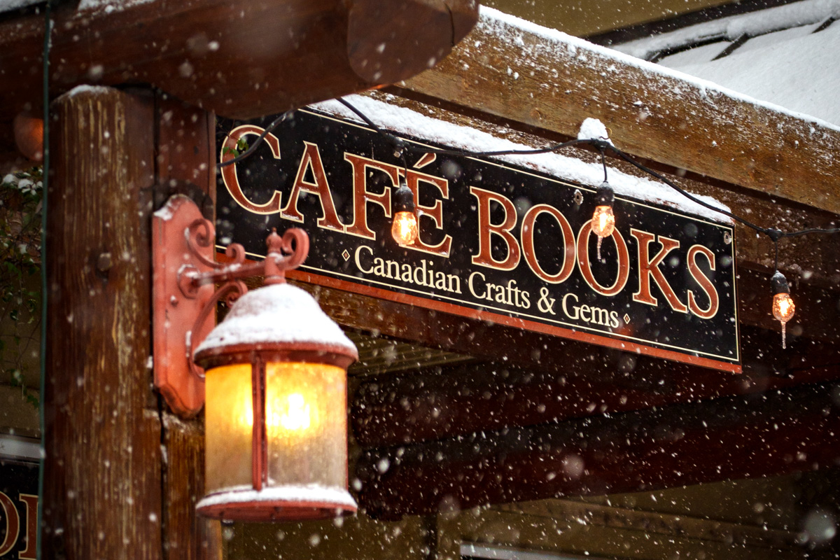 Devanture d’un café-librairie avec lanterne sous la neige, ambiance chaleureuse et hivernale