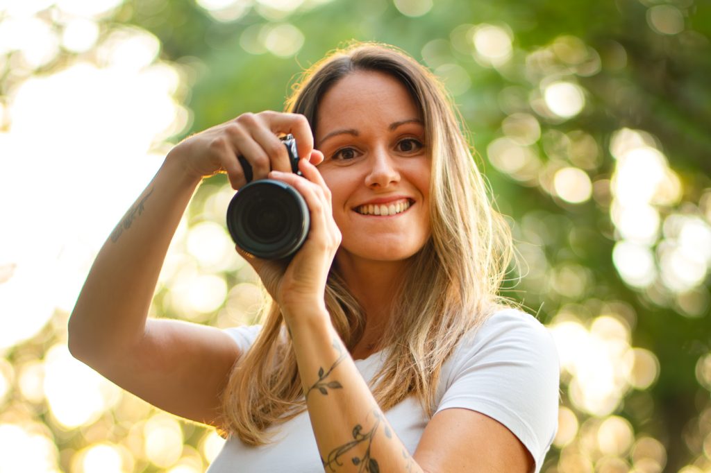 Laetitia Canciani photographe à toulouse entrain de prendre une photo en souriant