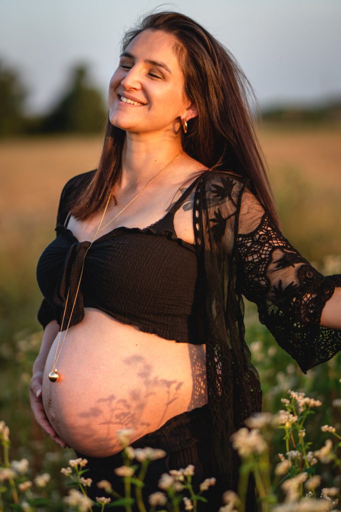 Une jeune femme enceinte épanouie dans un champ de blé en séance photo à Plaisance du Touch