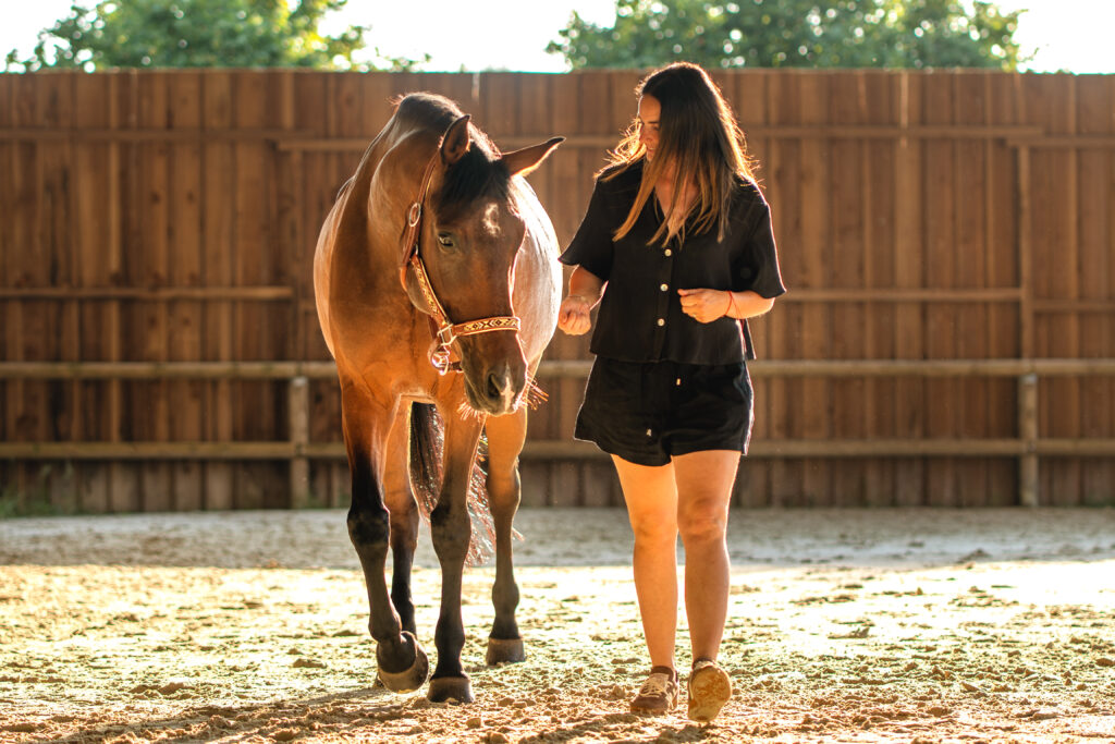 Une jeune fille marchant avec son cheval sous les rayons du soleil à Saint-Lys