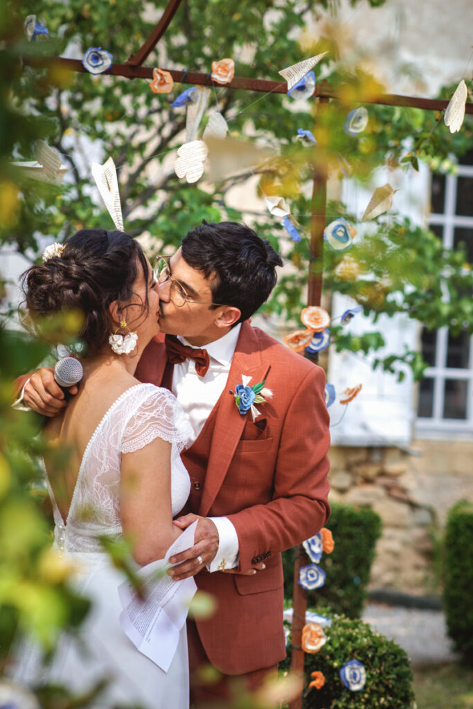 Un couple de mariés d'embrassant lors de leur cérémonie laïque de mariage