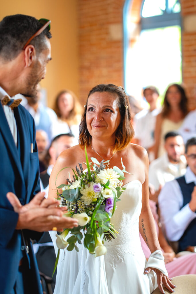 Une mariée qui regarde son mari lors de leur cérémonie de mariage à la mairie
