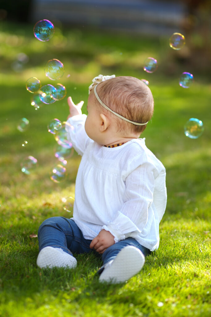 Un bébé qui joue avec des bulles de savon - séance photo famille