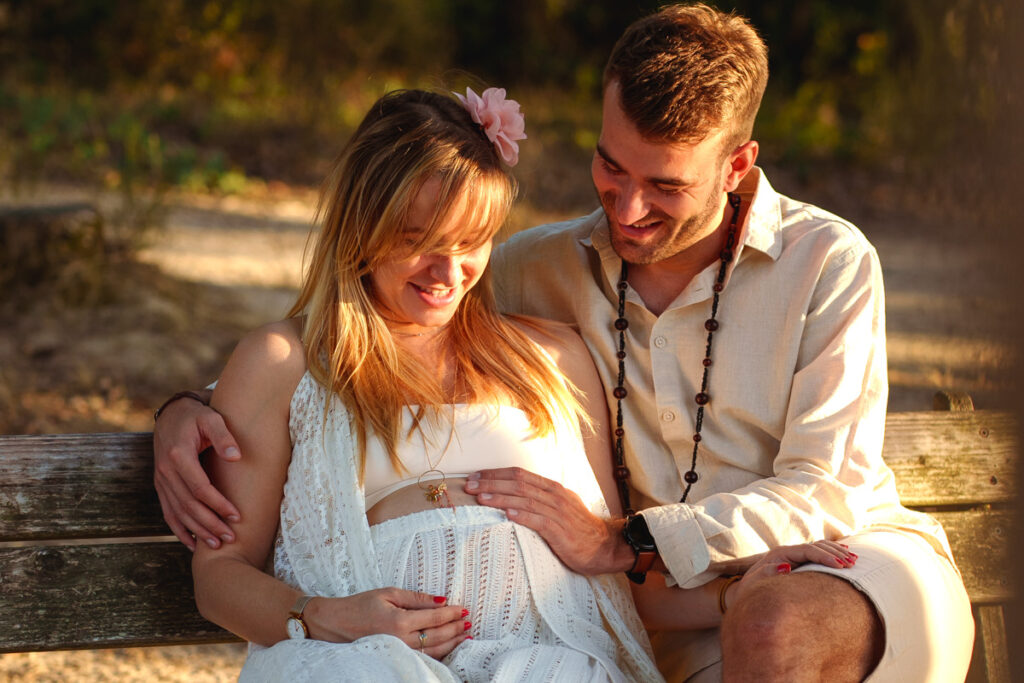 couple touchant et regardant le ventre rond de maman - séance photo grossesse