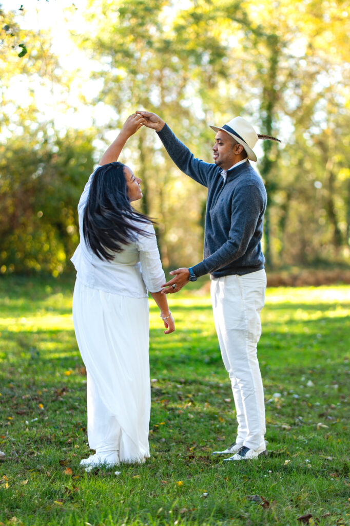 Un couple qui danse joyeusement dans une champ - séance photo couple à Toulouse