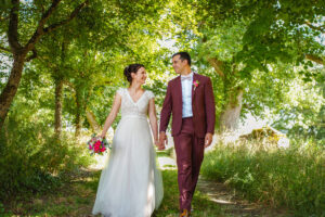 Un couple de mariés marchant main dans la main en se regardant amoureusement