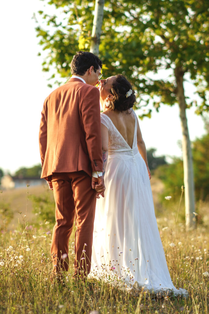 Un couple qui s'embrasse au coucher du soleil lors de la séance photo de leur mariage vers Toulouse