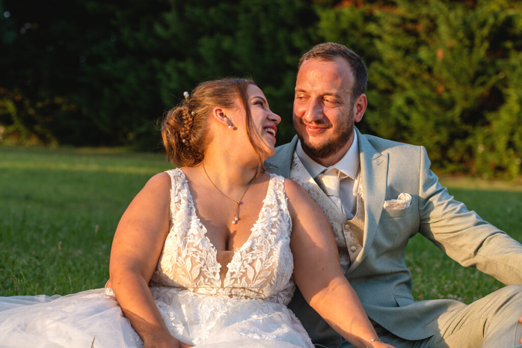 Un couple assis au coucher du soleil lors de leur mariage
