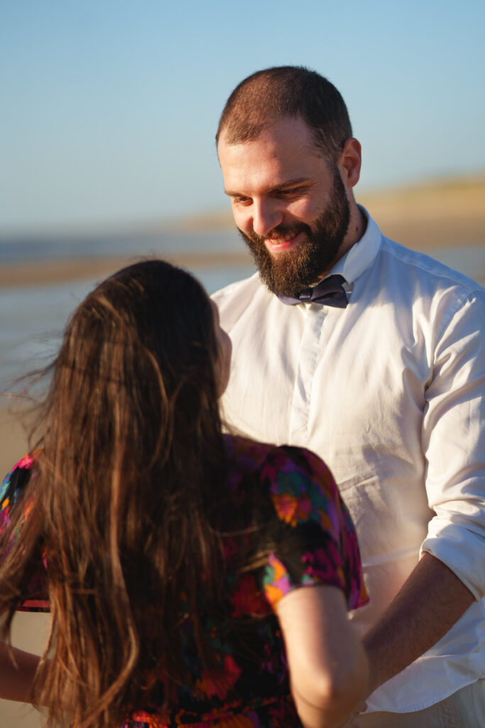 Un homme regardant amoureusement sa femme dans les yeux à la plage