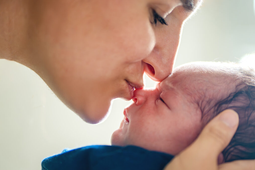 Une maman qui embrasse son nouveau-né sur le bout du nez - séance photo naissance à Toulouse