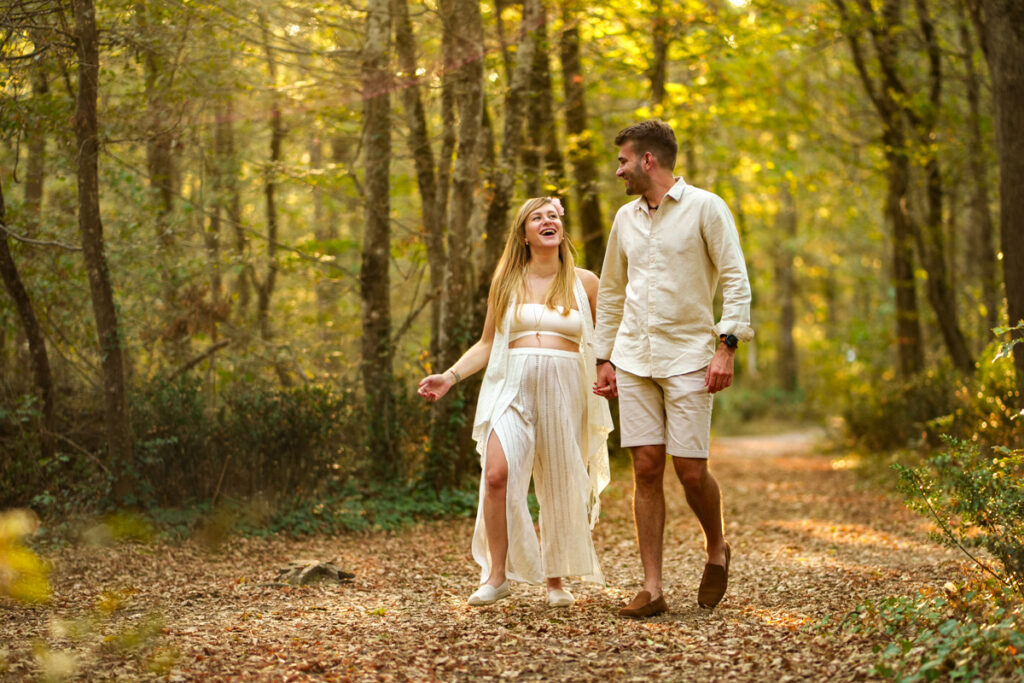 Un couple qui marche main dans la main lors d'une séance photo grossesse à Pibrac